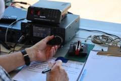 Someone using controls to tune an amateur radio transceiver.